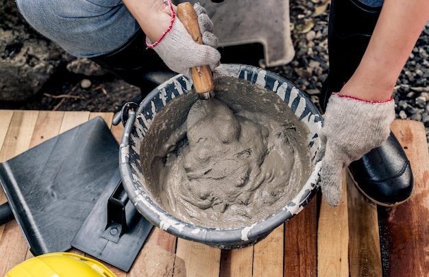 Trabalhador repara e conserta cerca de cimento em casa. Construção de bricolage e renovar a casa.