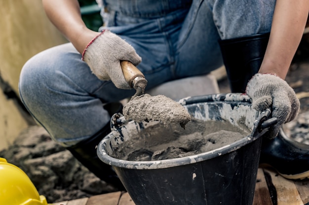 Trabalhador reparar e consertar a cerca de cimento em casa. Casa de construção e renovação de DIY.