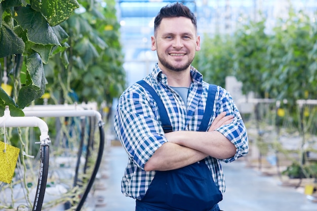 Trabalhador sorridente na plantação de vegetais