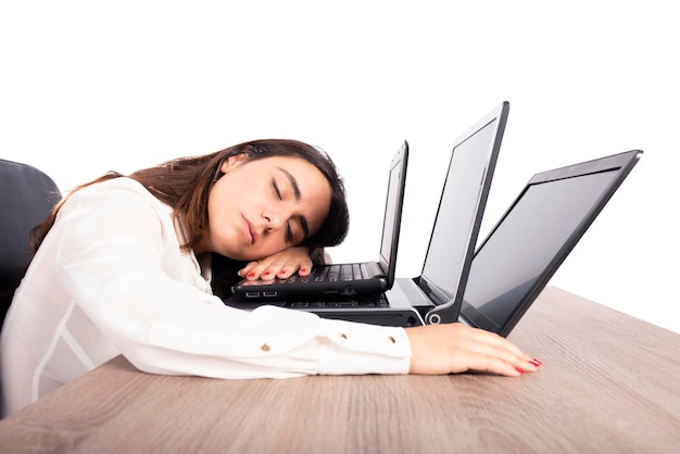 Trabalhadora adormece enquanto trabalha simultaneamente em três laptops