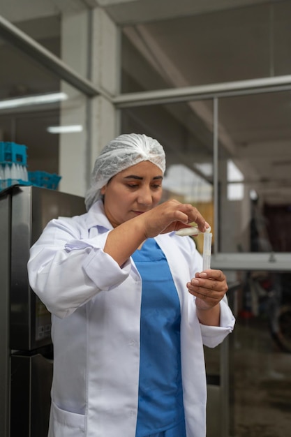 Trabalhadora coletando amostras de leite em uma fábrica de laticínios