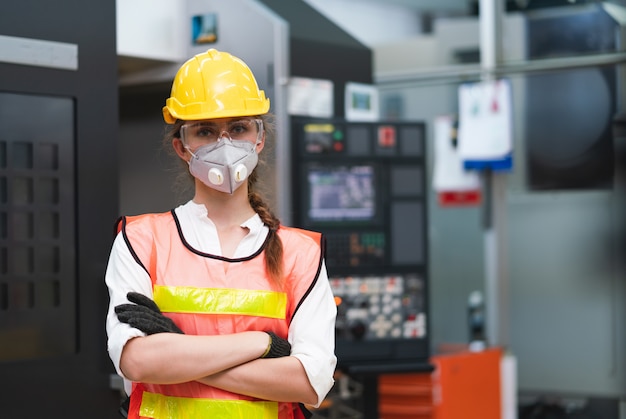 Trabalhadora com colete de segurança e capacete amarelo no trabalho