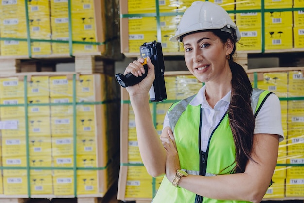 Trabalhadora da equipe trabalha no gerenciamento de coleta de produtos de inventário de armazém com dispositivo de digitalização de código de barras