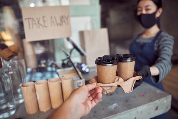 Trabalhadora dando um café delicioso ao cliente em um café moderno