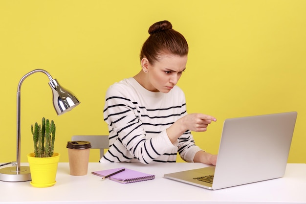 Trabalhadora de escritório com raiva apontando para a tela do laptop repreendendo e acusando falando em videochamada