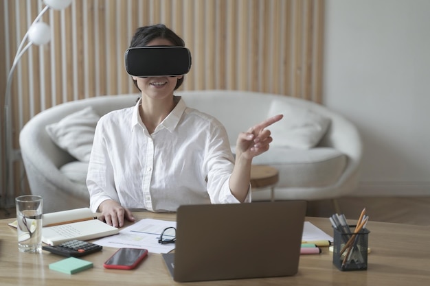 Foto trabalhadora de escritório feminina em fone de ouvido vr ou óculos de realidade virtual tocando objetos no ciberespaço