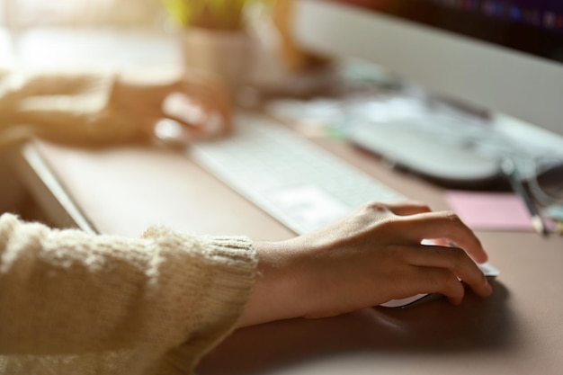 Trabalhadora de escritório ou funcionária de negócios trabalhando no computador e usando mouse sem fio