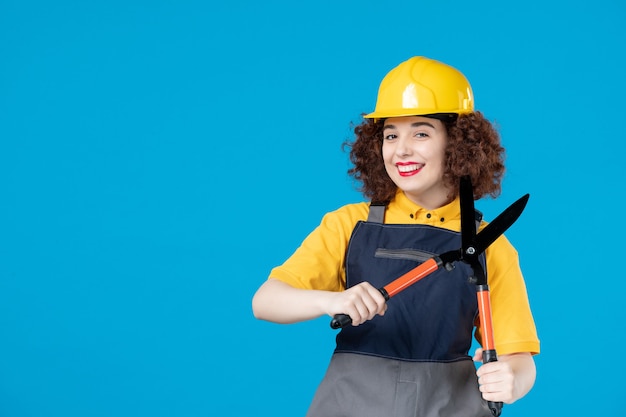 Trabalhadora de uniforme com tesouras de podar azul