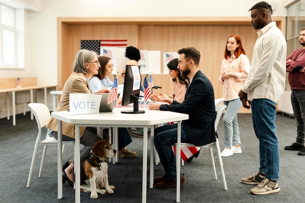 Foto trabalhadora eleitoral sênior registrando eleitor sentado à mesa no centro eleitoral democracia