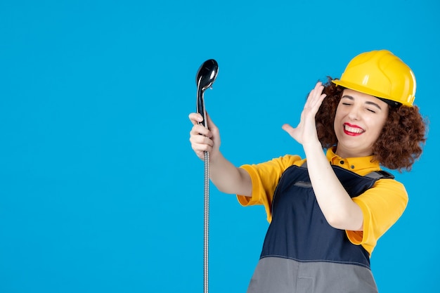 Trabalhadora em uniforme amarelo com chuveiro no azul