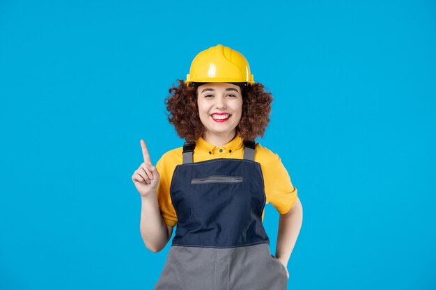 Trabalhadora em uniforme amarelo e capacete azul