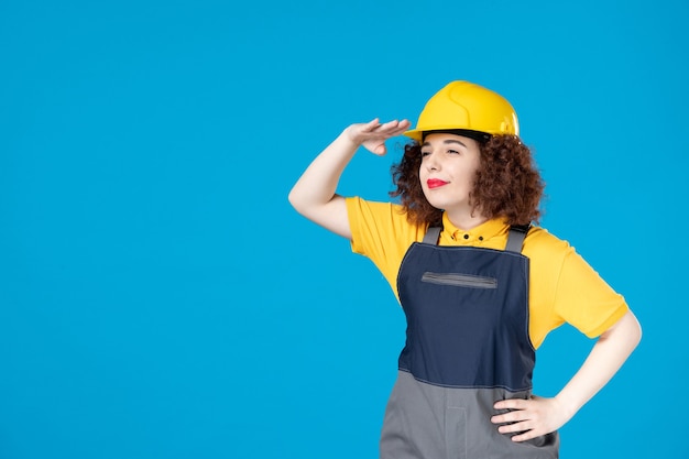 Trabalhadora em uniforme amarelo e capacete azul