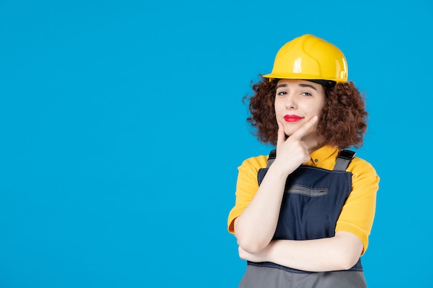 Trabalhadora em uniforme amarelo e capacete azul