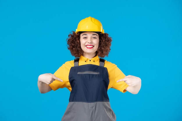 Trabalhadora em uniforme amarelo e capacete azul