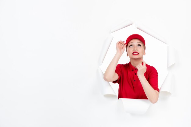 Trabalhadora em uniforme vermelho olhando para cima em papel branco