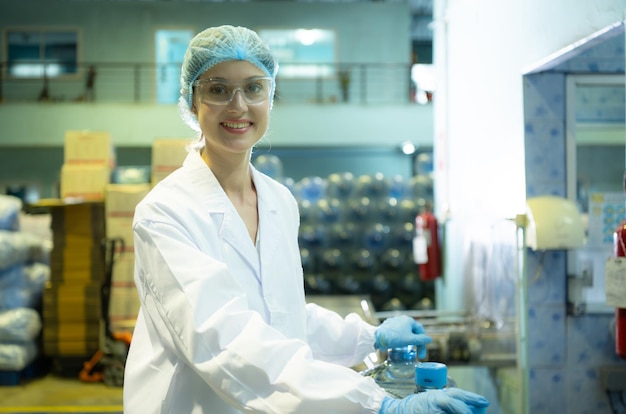 Trabalhadoras de controle de qualidade feminina em uma fábrica de água potável Inspecionando a qualidade dos tanques de água antes de importar o cinto de água potável para o tanque