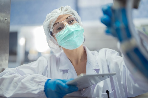 Trabalhadoras de fábrica verificam sistemas de máquinas na fábrica industrial