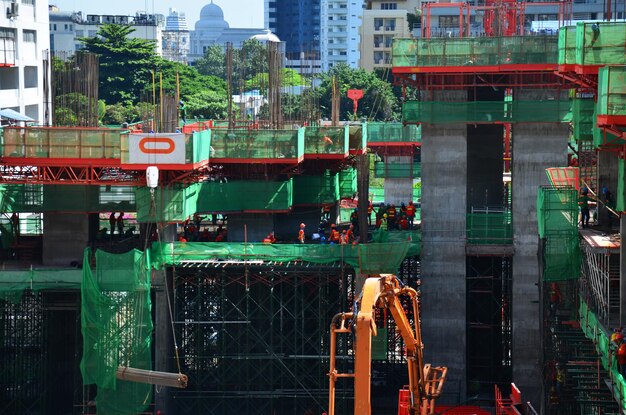 Trabalhadores asiáticos e trabalhadores tailandeses usam máquinas e máquinas pesadas, construtor de nova torre de construção no canteiro de obras em andaime na capital em Bangkok Tailândia