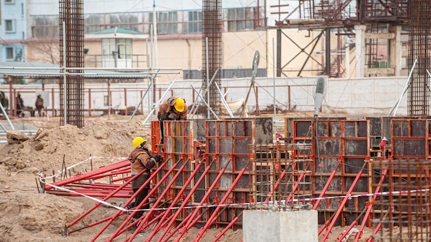 Trabalhadores com equipamento especial em um canteiro de obras fazem cofragem