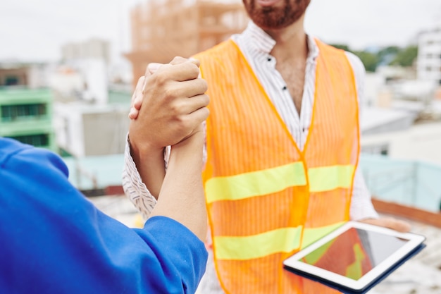 Trabalhadores da construção civil apertando as mãos