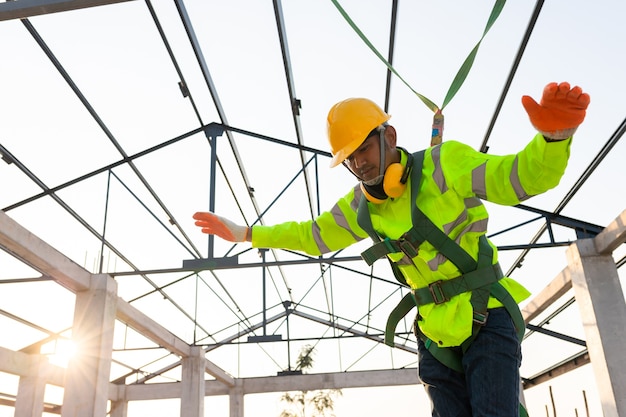 Trabalhadores da construção civil caem de altura, mas têm segurança para ajudar. Conceito de prevenção de perigos em altura com Segurança no canteiro de obras.