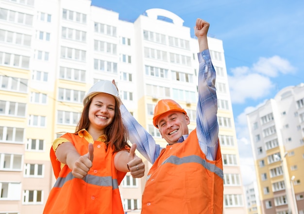 Trabalhadores da construção masculinos e femininos de sucesso contra casas