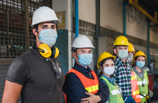 Trabalhadores da equipe usando máscara facial e capacete protetor