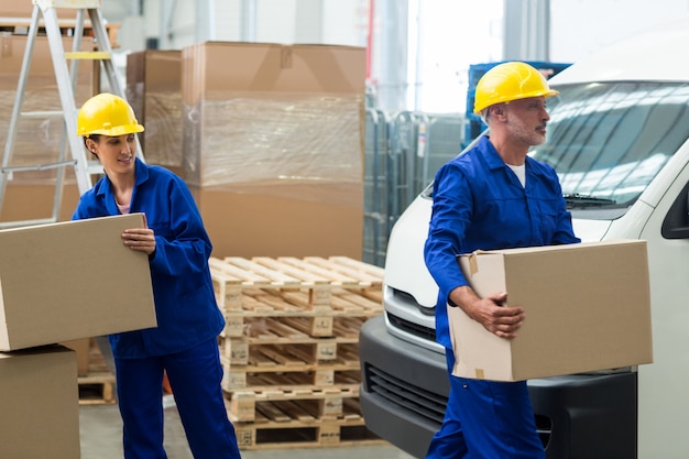 Trabalhadores de entrega descarregando caixas de papelão de palete