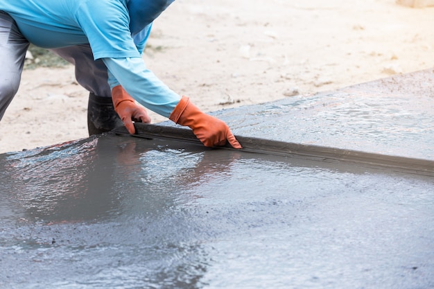 Foto trabalhadores de homens de construção de indústria com ferramenta mistura concreta na construção de estradas