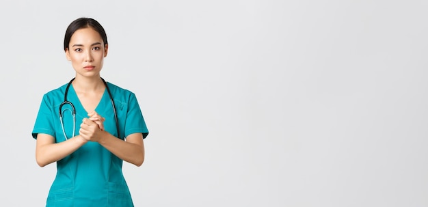 Trabalhadores de saúde Covid conceito pandêmico esperançoso médico enfermeiro asiático de aparência séria perguntando algo...