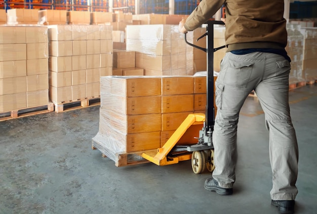 Foto trabalhadores descarregando caixas de embalagens em paletes em caixas da cadeia de abastecimento do armazém de armazenamento