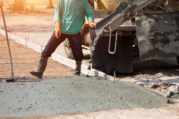 Trabalhadores despejando concreto com um caminhão betoneira