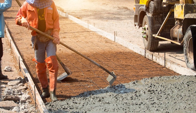 Trabalhadores despejando concreto com um caminhão betoneira