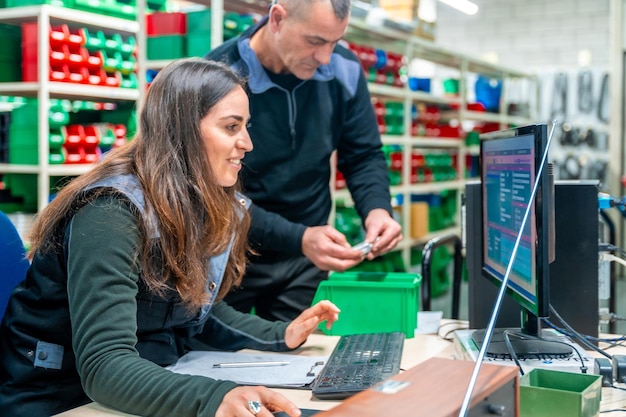 Trabalhadores que usam computador para fazer inventário em um centro logístico