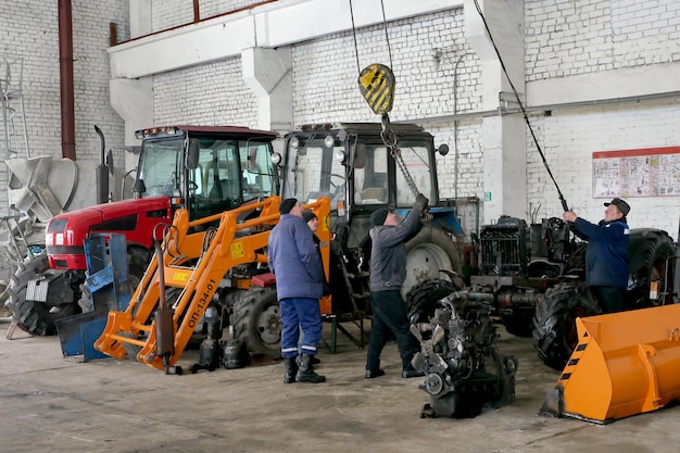 Foto trabalhadores reparam máquinas agrícolas antes do trabalho de campo