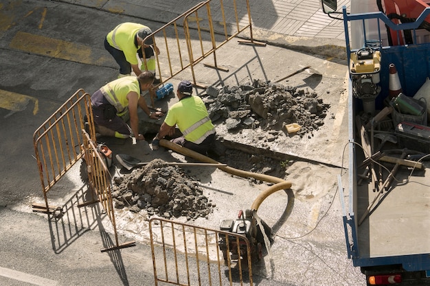 Trabalhadores reparando um cano de água quebrado na estrada