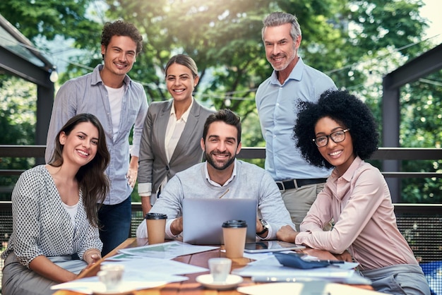 Trabalhamos onde quer que o clima nos atinja retrato recortado de um grupo de colegas de trabalho em uma reunião ao ar livre em um café