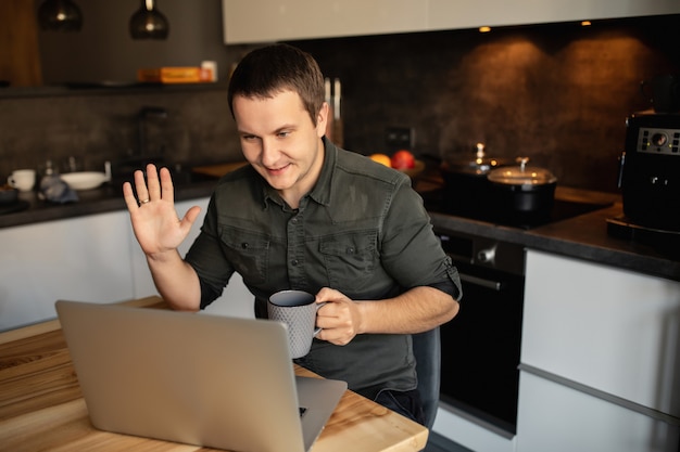 Trabalhando em casa. trabalhador realiza uma vídeo chamada, uma videoconferência com seus colegas no laptop dentro de casa. estudar on-line