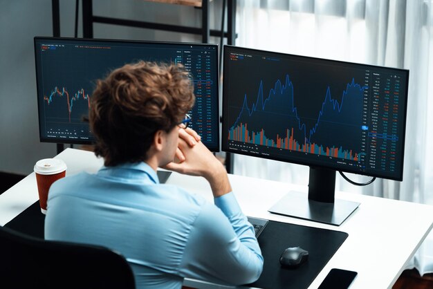 Trabalhando jovem comerciante de negócios focando PC com vista lateral de trás gusher
