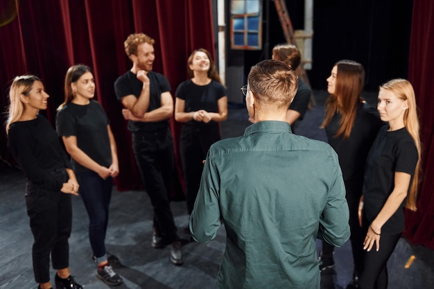 Trabalhando juntos grupo de atores em roupas de cor escura em ensaio no teatro