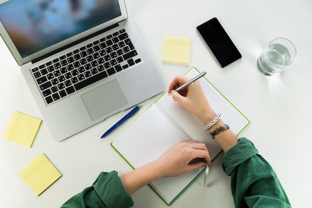 Trabalhando na mesa com o bloco de notas e o computador portátil