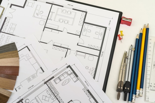 Trabalhando na mesa de escritório com plantas de casa para novo projeto e projeto de arquiteto de instrumentos de desenho de amostra de cores