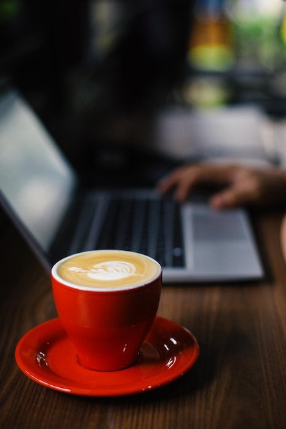 Trabalhando online em um laptop com café