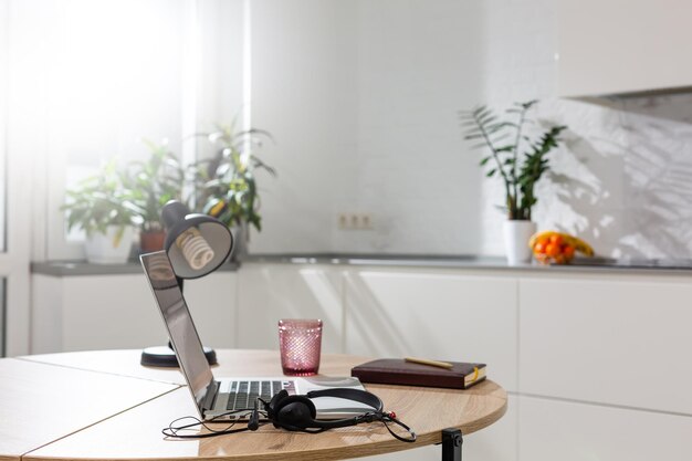 Trabalhar em casa - um laptop e um organizador em uma mesa de cozinha com cozinha ao fundo.