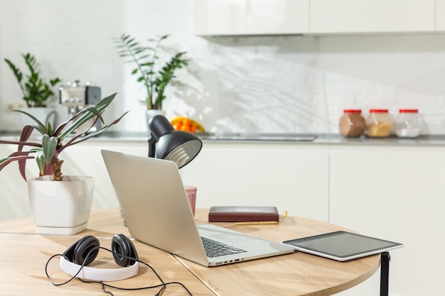 Trabalhar em casa - um laptop e um organizador em uma mesa de cozinha com cozinha ao fundo.