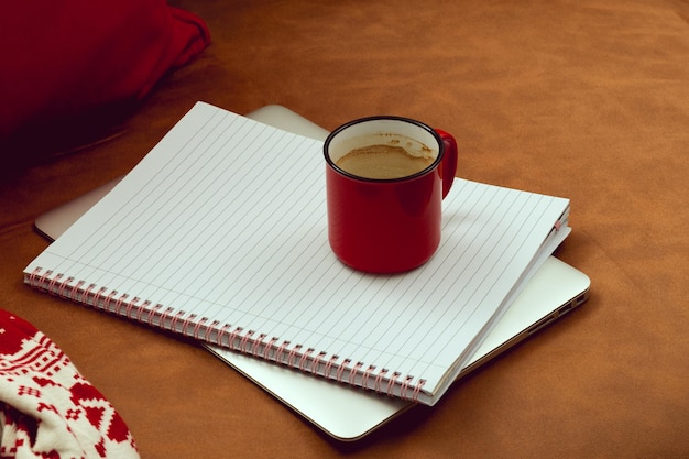 Trabalhe durante as férias de Natal Espaço de trabalho no sofá com uma xícara de café ao lado do bloco de notas