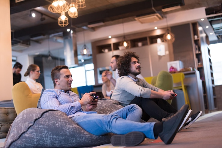 Foto trabalhe duro jogue duro. trabalhadores jogando jogos de computador em inicialização criativa office
