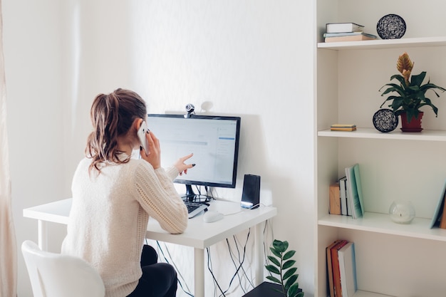 Trabalhe em casa durante a pandemia de coromavírus. Mulher fica em casa. Espaço de trabalho do freelancer. Interior do escritório com computador