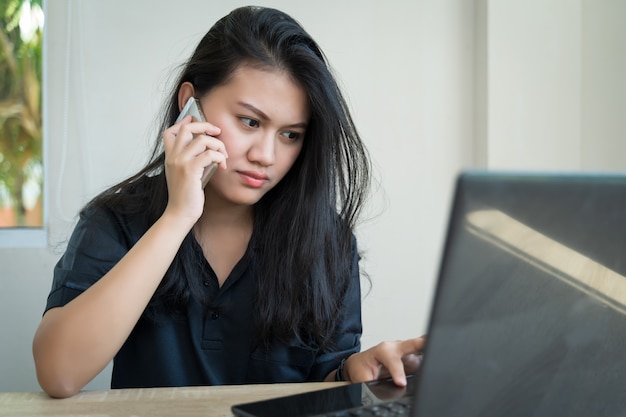 Trabalhe em casa durante o surto do vírus Asian Women Work from home use um laptop para trabalhar e ligue para a videoconferência de reuniões on-line com a equipe no conceito de tecnologia e negócios.