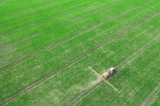 Trabalho agrícola de primavera nos campos. o trator pulveriza as plantações com herbicidas, inseticidas e pesticidas.